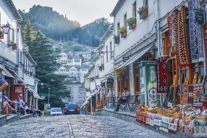 Rrugë e vjetër me gurë në pazarin e Gjirokastrës, me shtëpi të periudhës osmane